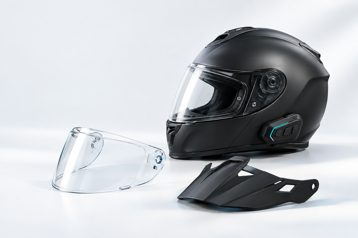 Black motorcycle helmet with a Bluetooth intercom, spare visor and peak.