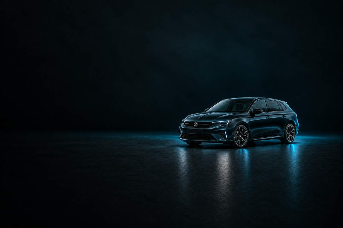 Black Vauxhall Astra hatchback in a dark studio with cyan lighting.